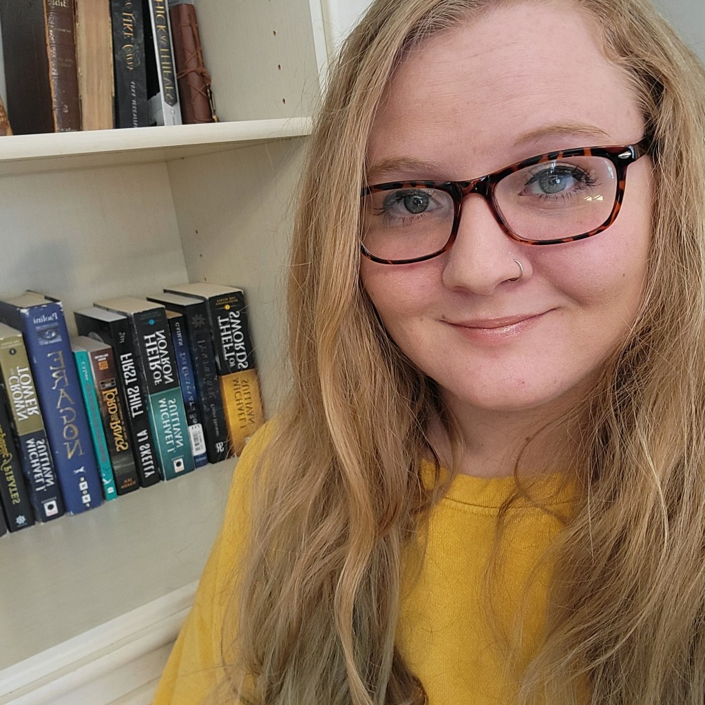 Anne J. Hill in front of bookshelf.