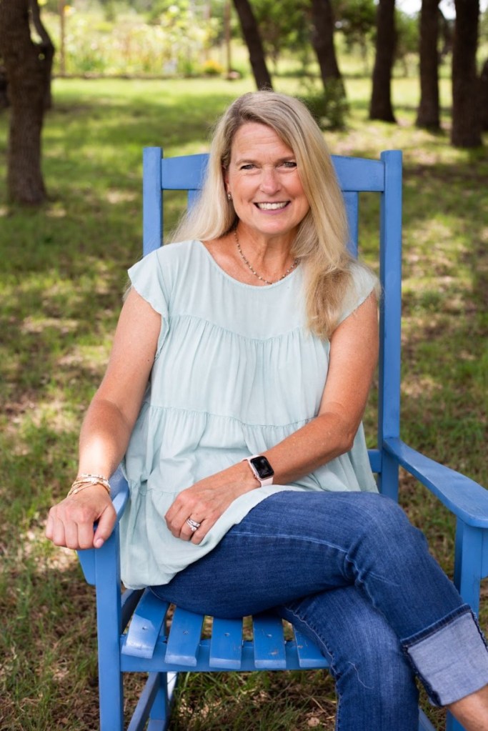 Author Jennifer Bosma sits in blue chair outside.