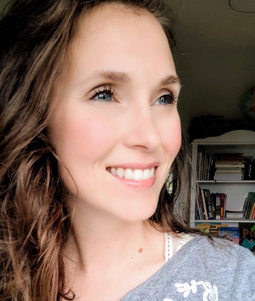 Author Brittany Eden's headshot with a bookshelf in the background. 