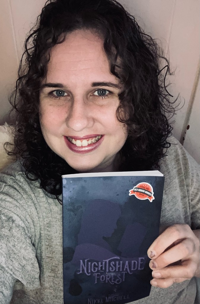 Author Nikki Mitchell poses with one of her books.