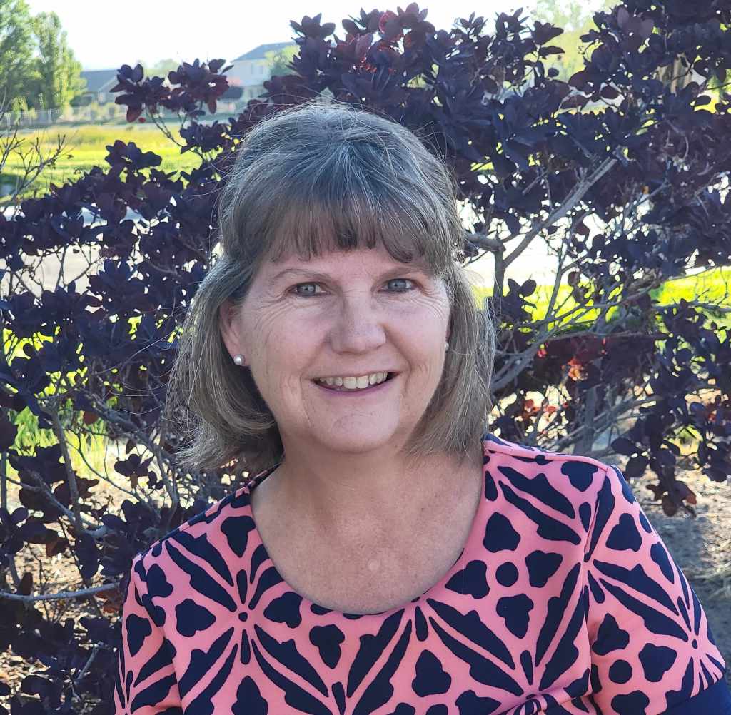 Nikki Hertzler smiles facing forward.